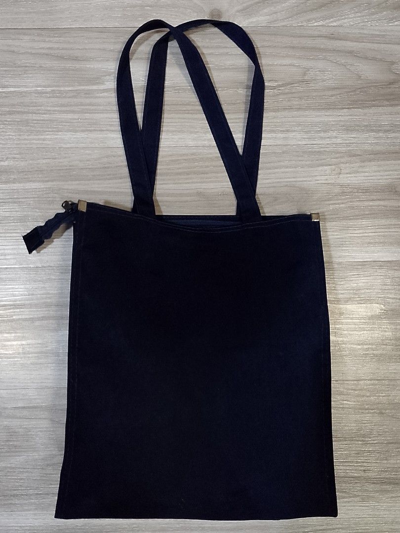 A plain vertical black canvas tote bag (Category: Tote Bags) located in Caloocan City. Submitted by pvaliao (Listing ID 1462363301, Image 1). Description: A plain vertical black canvas cotton tote bag with two shoulder straps resting flat. Fabric: cotton canvas Size: 12 inches × 14 inches Price: 100 Pre-owned Buy it now!.