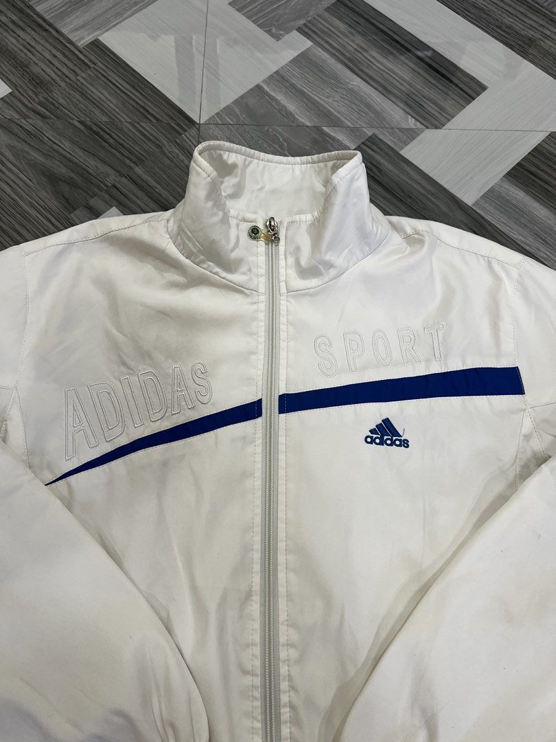 Adidas Sport White Track Jacket (Category: Coats, Jackets and Outerwear) located in Baguio. Submitted by zyddd014 (Listing ID 1462353302, Image 2). Description: - White Adidas track jacket - Blue accent details - Features 'Adidas' and 'Sport' text on the front - Full zip closure - Elasticated cuffs - Inner mesh lining - Perfect for casual wear or sports activities 400 Baguio loc.