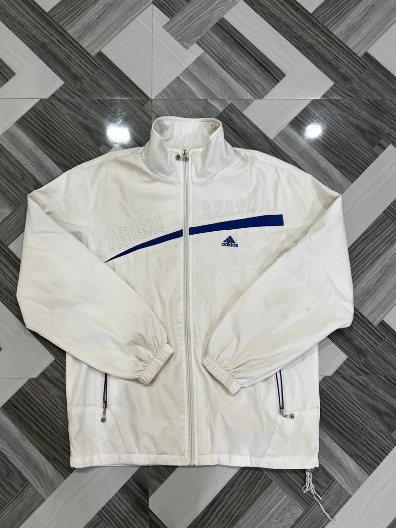 Adidas Sport White Track Jacket (Category: Coats, Jackets and Outerwear) located in Baguio. Submitted by zyddd014 (Listing ID 1462353302, Image 1). Description: - White Adidas track jacket - Blue accent details - Features 'Adidas' and 'Sport' text on the front - Full zip closure - Elasticated cuffs - Inner mesh lining - Perfect for casual wear or sports activities 400 Baguio loc.