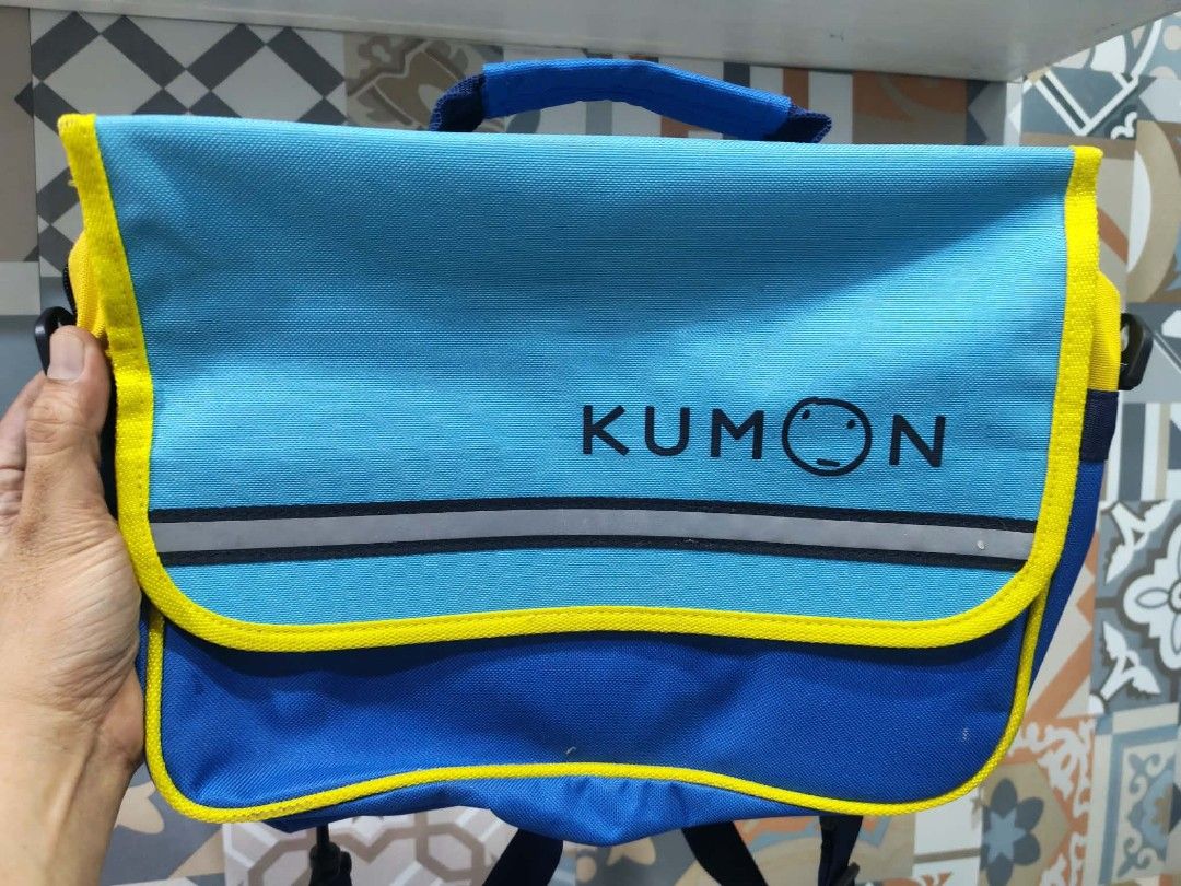 Authentic Kumon Student Bag / School Messenger Bag (Category: Sling Bags) located in Manila. Submitted by shanfern1412 (Listing ID 1462405420, Image 1). Description: Listing Details ​Brand: Kumon ​Item Type: Student Bag / Messenger Bag / School Bag ​Color: Blue with yellow trim and accents ​Design Features: Features the official Kumon logo on the front flap, a reflective safety stripe, a top carrying handle, and durable straps..