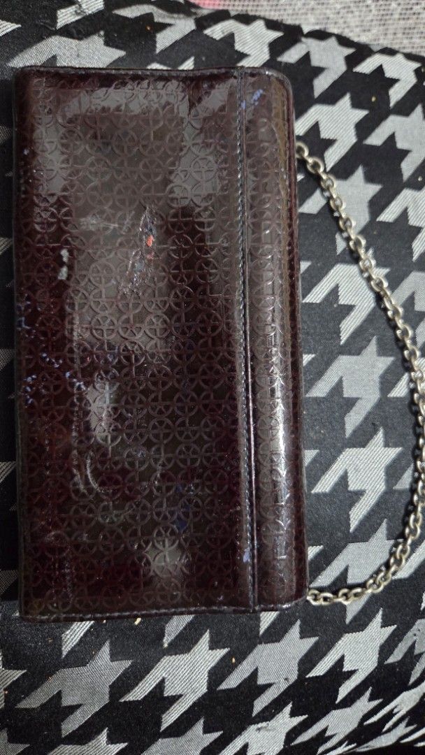 Bean Pole Patent Leather Wallet with Chain (Category: Luxury Bags & Wallets) located in Quezon City. Submitted by kctheexplorer05 (Listing ID 1462331488, Image 2). Description: - Dark brown patent leather wallet from Bean Pole - Features a repeating pattern - Includes a silver chain strap - Interior: multiple card slots, zippered compartment, clear ID windows - Still a functional and stylish accessory -has sign of usage -WYIWYG .