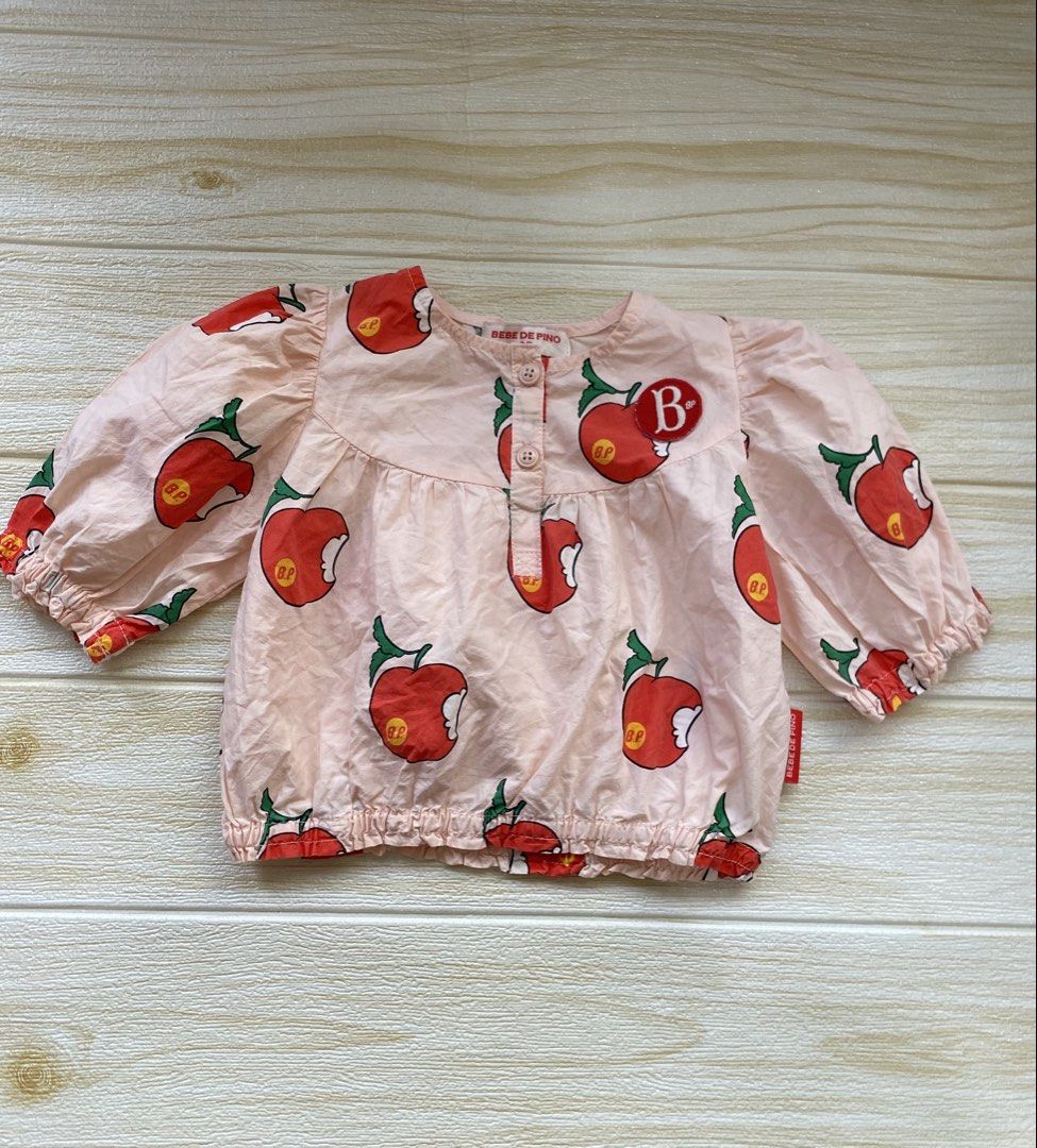 Bebe de Pino Puff Sleeve Blouse (Category: Babies & Kids Fashion) located in Cebu City. Submitted by yjainani (Listing ID 1462375378, Image 1). Description: peach-colored children's All Over Pomme Puff Sleeve Blouse from Bebe De Pino featuring an all-over apple print and a "B" letter patch detail best fit 12m.