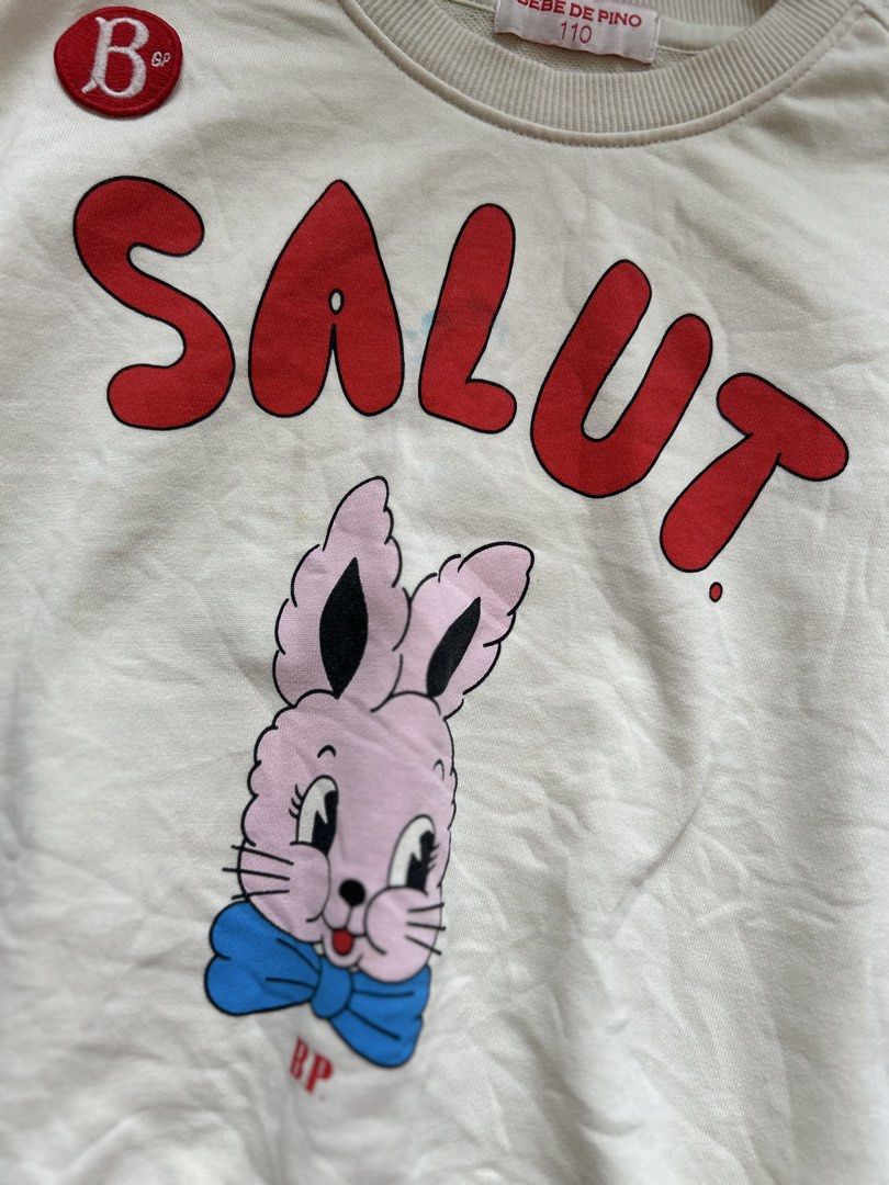 Bebedepino short-sleeve sweatshirt (Category: Babies & Kids Fashion) located in Cebu City. Submitted by yjainani (Listing ID 1462373381, Image 3). Description: cream-colored Bebedepino short-sleeve sweatshirt featuring a cute pink bunny graphic and bold red "SALUT" lettering.