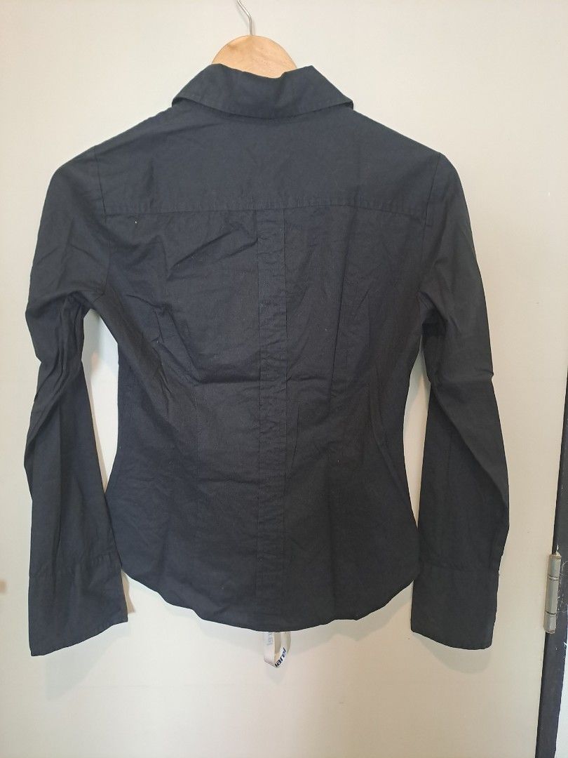 Benetton black longsleve (Category: Longsleeves) located in Manila. Submitted by joanbalde39643 (Listing ID 1462368170, Image 2). Description: This is a women's fitted long-sleeve button-down shirt from the brand United Colors of Benetton. It features a classic pointed collar, a tailored silhouette with front darting for a contoured fit, and tonal black buttons down the placket..
