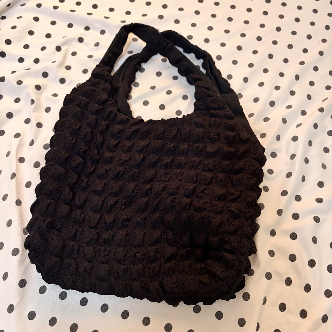 Black Textured Tote Bag (Category: Tote Bags) located in Pasay City. Submitted by notellyyyy (Listing ID 1462279204, Image 1). Description: - Stylish black tote bag - Unique textured fabric with a crinkled, bubbly appearance - Two comfortable shoulder straps - Spacious interior for daily essentials - Versatile for casual outings.