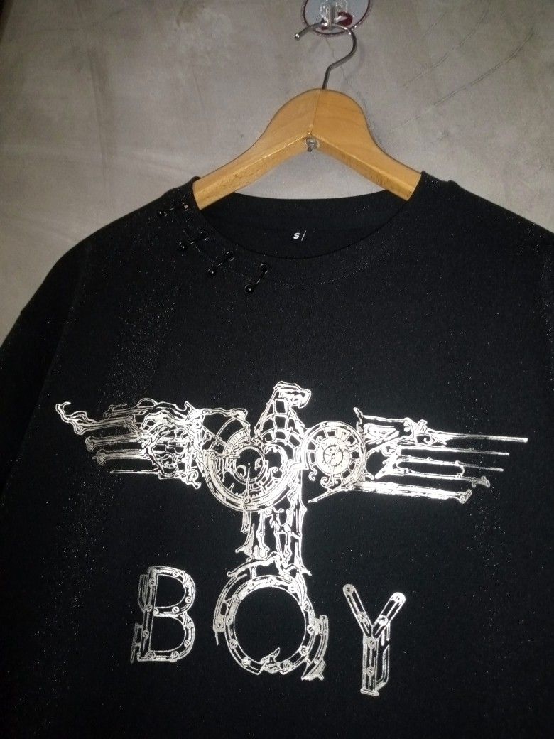Boy London Men's Tshirt Authentic (Category: Tshirts & Polo Shirts ) located in Manila. Submitted by boldfalcon.38de78 (Listing ID 1462298650, Image 3). Description: This black Boy London t-shirt features the brand's iconic silver eagle graphic on the chest with unique shoulder grommet and ring detailing near the collar Boy London AUTHENTIC Men's Tshirt As new Condition Size Small W-21 L-27.5 10/10 color rate Issue Cut Neck tag But Authentic Loca
