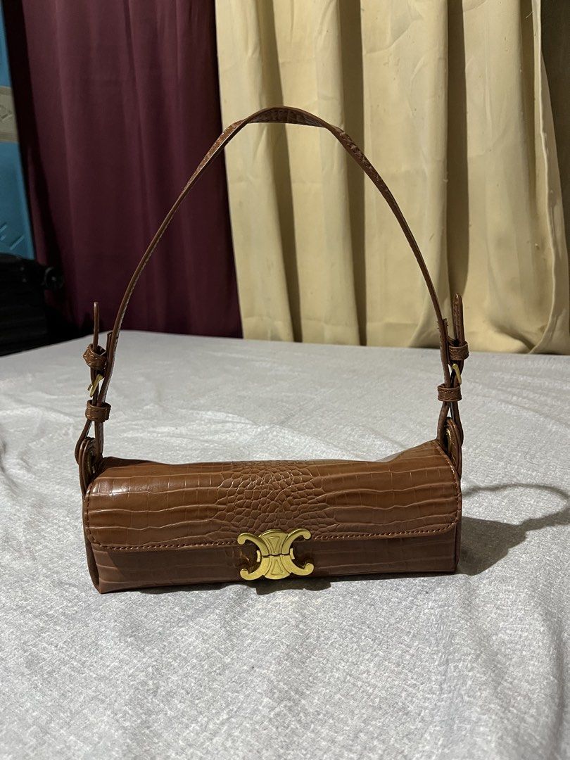 Brown Shoulder Bag with Gold Clasp (Category: Shoulder Bags) located in Manila. Submitted by az0r_ (Listing ID 1462410478, Image 2). Description: - Stylish brown shoulder bag - Unique croc-embossed texture - Trendy cylinder shape - Secure gold clasp closure - Adjustable strap with buckles - Ideal for carrying daily essentials - Complements various outfits.