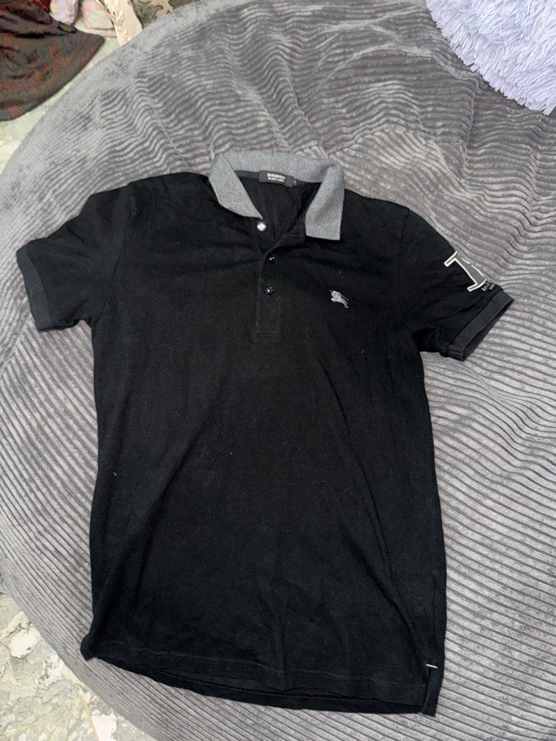 Burberry Black Label Polo Shirt (Category: Tshirts & Polo Shirts ) located in Angeles City. Submitted by migs_font29 (Listing ID 1462391783, Image 1). Description: - Authentic Burberry Black Label polo shirt - Size: 2 - Color: Black with grey collar and sleeve details - Features iconic Burberry knight logo on the chest - Large 'B' logo detail on the sleeve - Perfect for stylish casual wear.