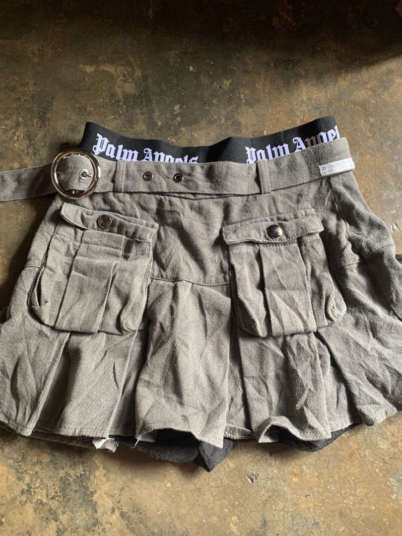 cargo skort (Category: Skirts) located in Valenzuela. Submitted by lovedeclutterph (Listing ID 1462286752, Image 1). Description: - Palm Angels grey cargo skirt - Belted waist - Multiple pockets - Pleated design - Black waistband - Built-in shorts - Ideal for streetwear style.