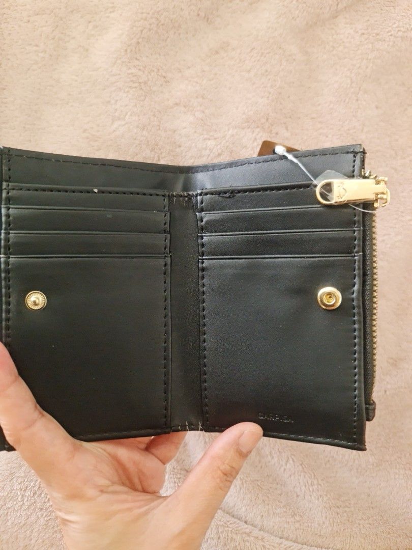 Carpisa wallet (Category: Wallets & Card holders) located in Marilao. Submitted by joycehart (Listing ID 1462287896, Image 2). Description: - Cute black wallet with textured exterior - Small flower detail on front closure - Multiple card slots inside - Zippered coin pocket - Gold-tone zipper and snap button - Comes with original tag.