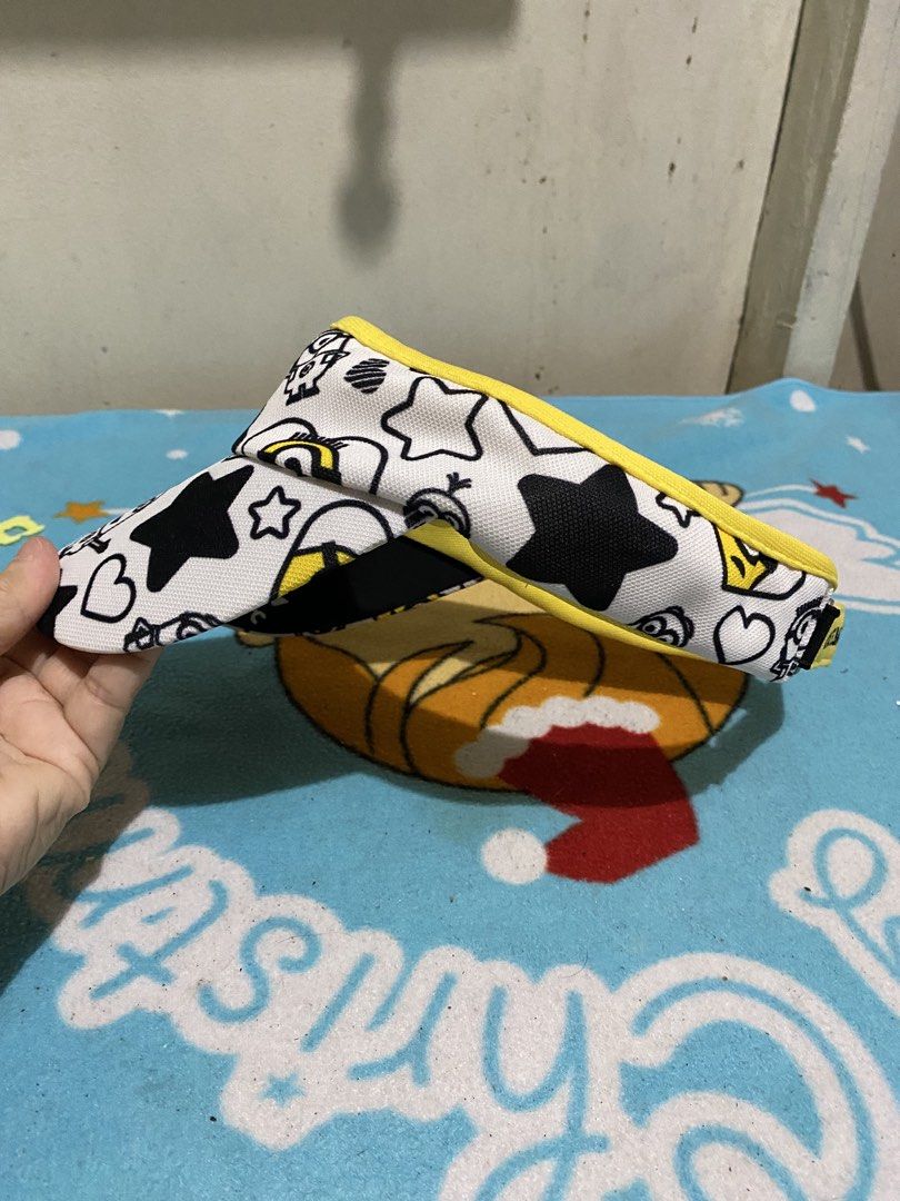 Castelbajac Minions Visor Cap (Category: Caps & Hats) located in Manila. Submitted by resi.diaz (Listing ID 1462400044, Image 3). Description: - Adorable visor cap featuring a fun Minions print. - Playful black stars and hearts scattered across the design. - Bright yellow trim and brim for a pop of color. - Adjustable strap at the back for a comfortable, customized fit. - Ideal accessory for sunny days and outdoor adventures. - A must-have for an