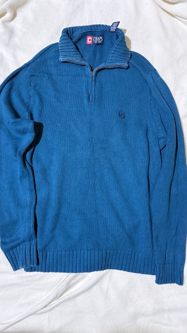 Chaps Blue Cotton Blend Quarter Zip Sweater (Category: Coats, Jackets and Outerwear) located in Balanga. Submitted by jayfinds013 (Listing ID 1462333182, Image 1). Description: - Blue Chaps sweater - Comfortable cotton blend material - Stylish quarter zip neckline - Ribbed cuffs and hem for a snug fit - Features a small embroidered Chaps logo on the chest - Versatile for layering or wearing solo - Measurements in inches: Tag - Small Shoulder - 19