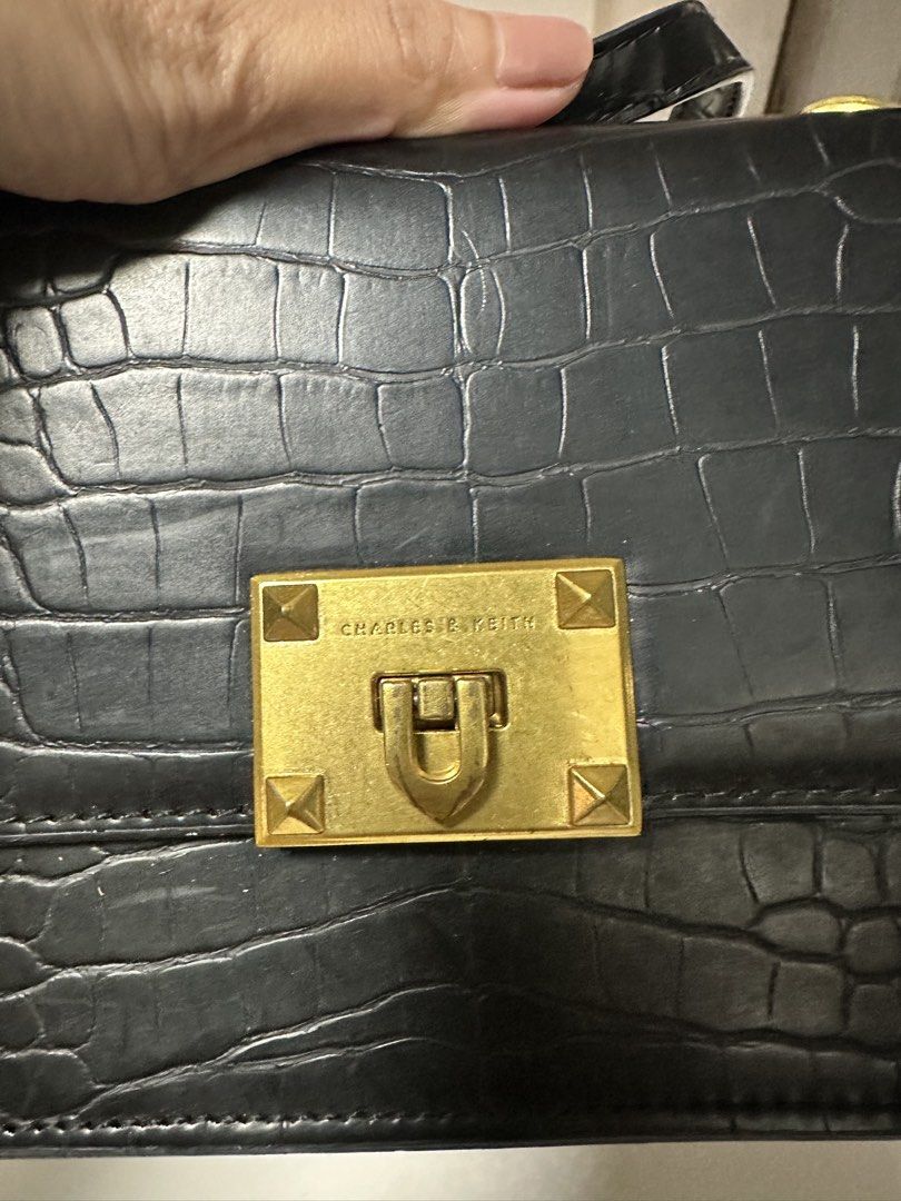 Charles & Keith Black Croc Embossed Chain Shoulder Bag (Category: Shoulder Bags) located in Quezon City. Submitted by fashion4less__ (Listing ID 1462347965, Image 2). Description: - Black shoulder bag with stylish croc-embossed texture. - Elegant gold chain strap and hardware. - Secure turn-lock closure. - Includes an interior zippered compartment for essentials. - Ideal for evening events or adding a touch of sophistication to your look..
