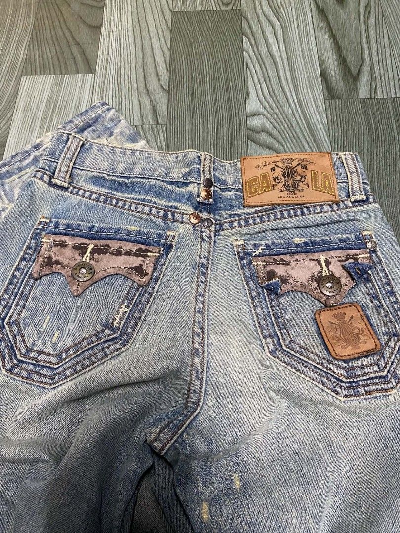 Christian Audigier Jeans (Category: Jeans) located in Pasig City. Submitted by jstnisidor81288 (Listing ID 1462420617, Image 3). Description: - Light wash denim jeans - Distressed details for a stylish look - Unique pocket designs - Branding on the back - Straight leg fit - Some fading and wear consistent with the style - A great statement piece size 27 length 38.