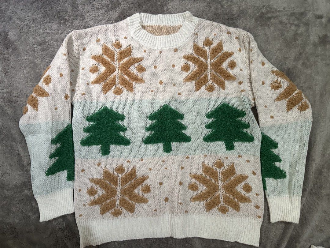 Christmas Snowflake & Tree Knit Sweater (Category: Coats, Jackets and Outerwear) located in Bulacan. Submitted by dyna01 (Listing ID 1462387275, Image 1). Description: - Cozy knit sweater perfect for Christmas! - Features festive snowflake and green tree design. - White base with charming brown and green accents. - Ribbed cuffs and hem for a snug fit. - Looks super warm and comfortable for holiday wear..