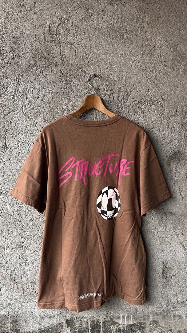 Chrome Hearts Brown Pocket Tee Structure Smiley (Category: Tshirts & Polo Shirts ) located in Cabuyao City. Submitted by bulandos (Listing ID 1462409828, Image 2). Description: - Authentic Brown Chrome Hearts T-Shirt - Made in USA - Chest pocket with Chrome Hearts logo - Back features 'STRUCTURE' text and a checkered smiley face graphic - Cute monster graphic on the front bottom left.