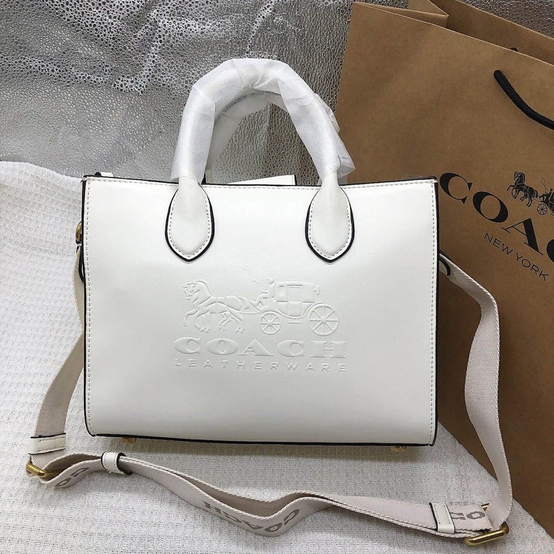 Coach Leatherware White Tote Bag with Strap (Category: Community) located in Angeles City. Submitted by migs_font29 (Listing ID 1462433470, Image 1). Description: - Authentic Coach tote bag - Embossed horse and carriage logo on front - Elegant leatherware details - Detachable shoulder strap included - Luxurious brown suede interior lining - Secure zipper closure - Comes with original silica gel packet.