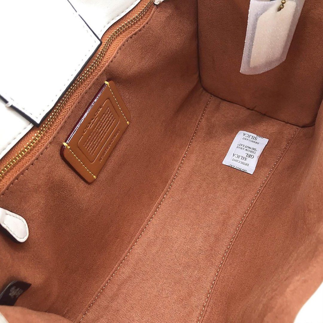 Coach Leatherware White Tote Bag with Strap (Category: Community) located in Angeles City. Submitted by migs_font29 (Listing ID 1462433470, Image 2). Description: - Authentic Coach tote bag - Embossed horse and carriage logo on front - Elegant leatherware details - Detachable shoulder strap included - Luxurious brown suede interior lining - Secure zipper closure - Comes with original silica gel packet.