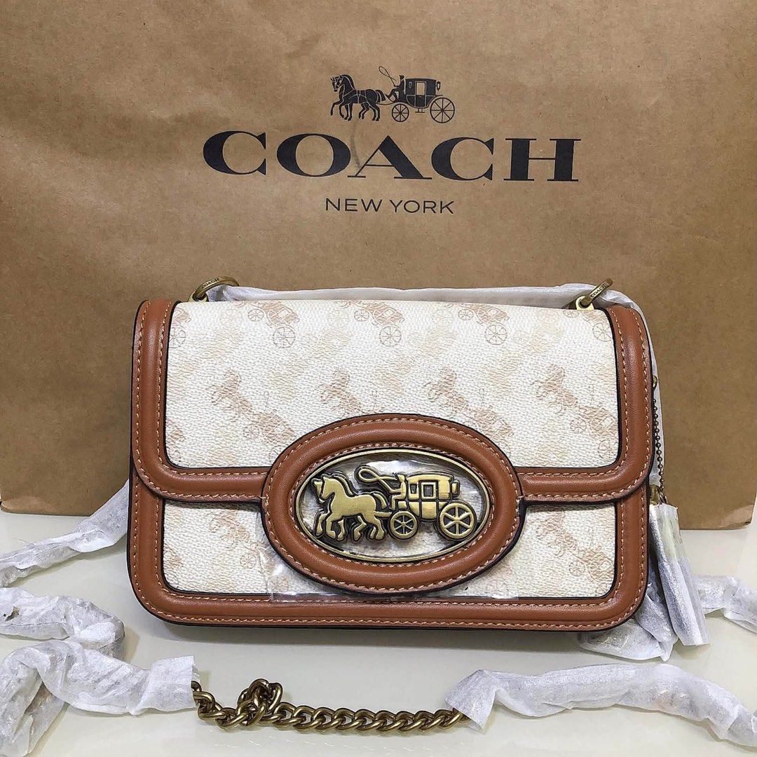 Coach Signature Canvas & Leather Shoulder Bag (Category: Voice Recorders) located in Angeles City. Submitted by migs_font29 (Listing ID 1462369938, Image 1). Description: - Authentic Coach shoulder bag - Signature print with tan leather trim - Iconic horse and carriage emblem on front - Interior zippered pocket - Coach creed patch - Made in Cambodia - Comes with original dust bag.