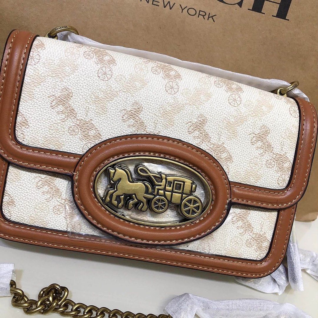 Coach Signature Canvas & Leather Shoulder Bag (Category: Voice Recorders) located in Angeles City. Submitted by migs_font29 (Listing ID 1462369938, Image 3). Description: - Authentic Coach shoulder bag - Signature print with tan leather trim - Iconic horse and carriage emblem on front - Interior zippered pocket - Coach creed patch - Made in Cambodia - Comes with original dust bag.