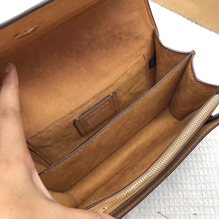Coach White & Tan Studded Shoulder Bag (Category: Community) located in Angeles City. Submitted by migs_font29 (Listing ID 1462378131, Image 2). Description: - White leather shoulder bag with tan signature canvas panel - Elegant gold hardware and stud details - Spacious interior with multiple compartments and a zip pocket - Comes with original dust bag and packaging - Versatile for day or night use.