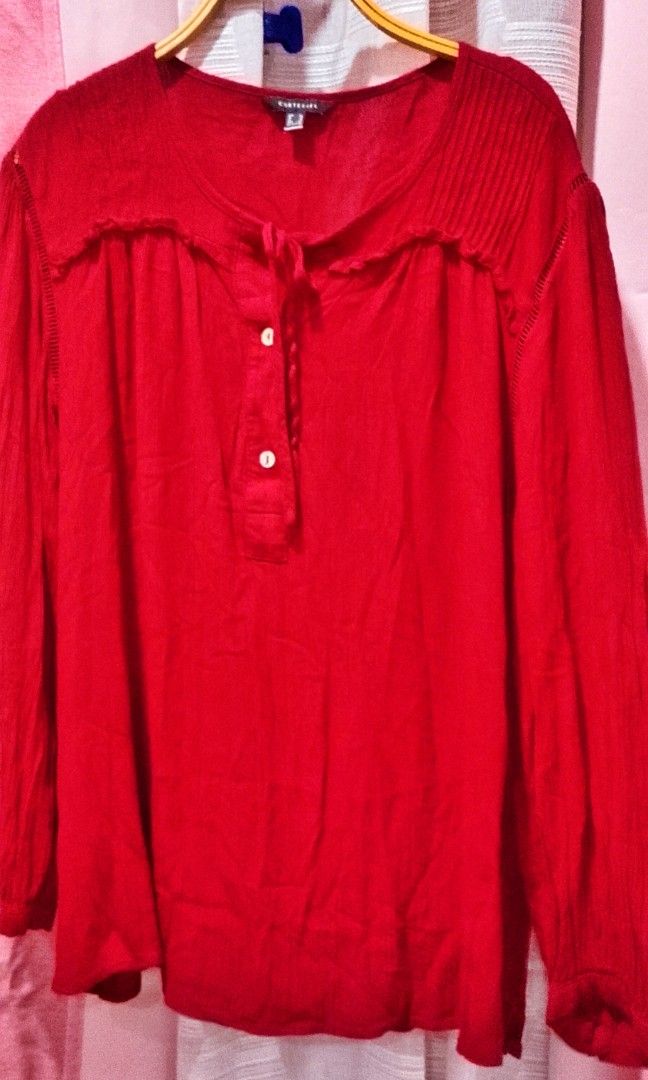 Cortefiel red cherry top XL (Category: Blouses) located in Cabanatuan. Submitted by miss.maia (Listing ID 1462406851, Image 2). Description: The Cortefiel top shown in the image is a long-sleeved, deep red bohemian-style peasant blouse. It features a fractional front button placket with a self-tie tassel or drawstring closure at the neckline, vertical pleated/pintuck shoulder details, and a loose, flowing silhouette..