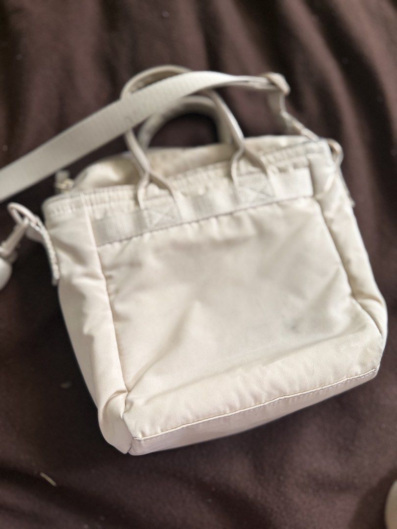 Cream Nylon Tote Bag with Shoulder Strap (Category: Tote Bags) located in Quezon City. Submitted by msmarjqab (Listing ID 1462333864, Image 3). Description: - Cream colored nylon tote bag - Features top handles and a detachable shoulder strap - Main compartment with secure zip closure - Convenient front stitched pocket detail - Lightweight and practical for everyday use - Ideal size for carrying your essentials - Shows light signs of gentle use w