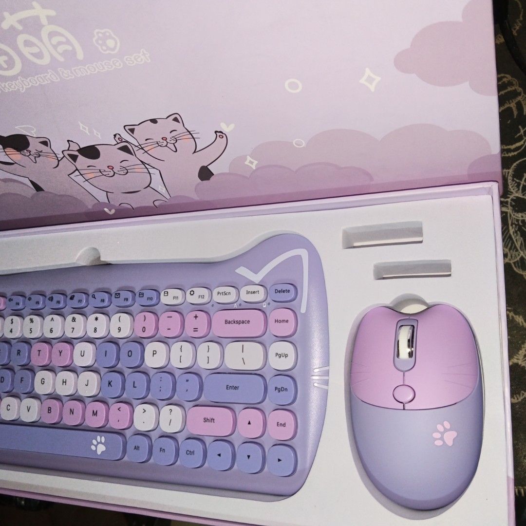Cute Cat Wireless Keyboard and Mouse Set (Category: Computer Keyboard) located in Caloocan City. Submitted by coolgem_3f10a0 (Listing ID 1462403006, Image 2). Description: - Adorable cat-themed wireless keyboard and mouse set - Sweet pastel purple and pink colors - Features cute cat ear designs on both keyboard and mouse - Adds a fun and cute touch to your desk setup - Ideal for students or anyone who loves cute accessories.