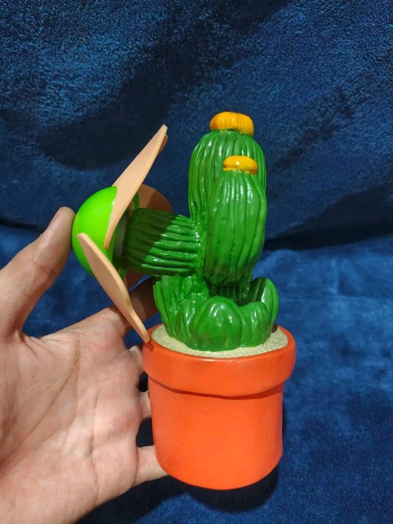 Cute Potted Cactus Figurine with Orange Pot (Category: Other Home Decor) located in Manila. Submitted by kirstentoyshub (Listing ID 1462379977, Image 2). Description: DECLARED NOT WORKING. GOOD FOR DISPLAY COLLECTION - Adorable potted cactus figurine - f - Features a bright orange pot and green cactus with yellow tops - Includes a cute green ball with light brown accents - Bottom of pot shows internal wiring/components - Ideal for desk decor or a