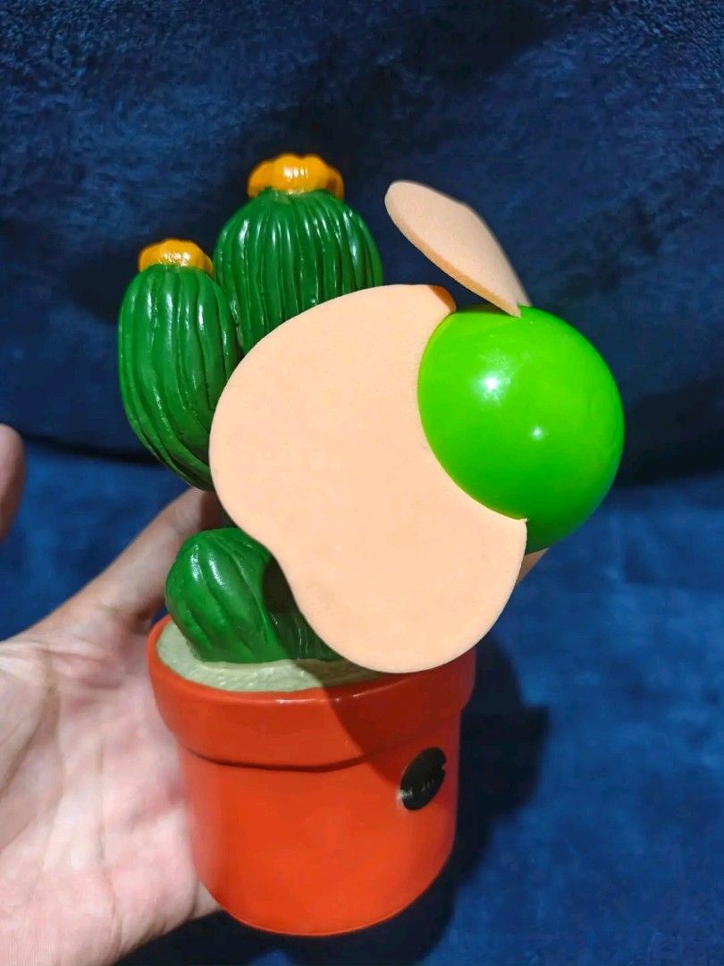 Cute Potted Cactus Figurine with Orange Pot (Category: Other Home Decor) located in Manila. Submitted by kirstentoyshub (Listing ID 1462379977, Image 1). Description: DECLARED NOT WORKING. GOOD FOR DISPLAY COLLECTION - Adorable potted cactus figurine - f - Features a bright orange pot and green cactus with yellow tops - Includes a cute green ball with light brown accents - Bottom of pot shows internal wiring/components - Ideal for desk decor or a