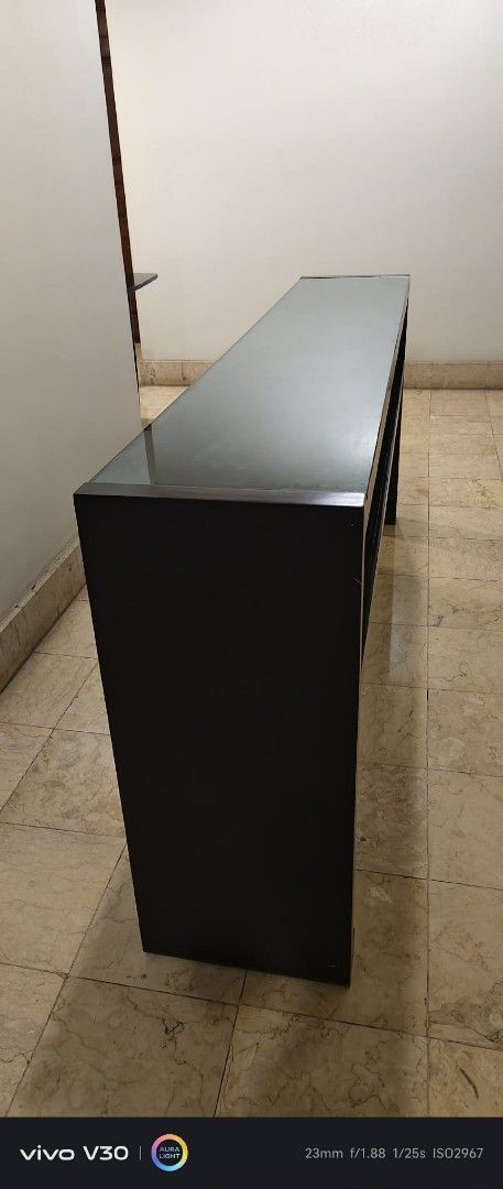 Dark Wood Console Table with Glass Top (Category: Tables & Sets) located in Taguig. Submitted by thrifthub.ph (Listing ID 1462291176, Image 3). Description: CONDO PULL-OUT!! NEED TO DISPOSED ASAP!! Elegant dark wood console table with clear glass top and open shelf. Perfect for entryways or behind sofas. 1.5m long. Selling due to redecoration..