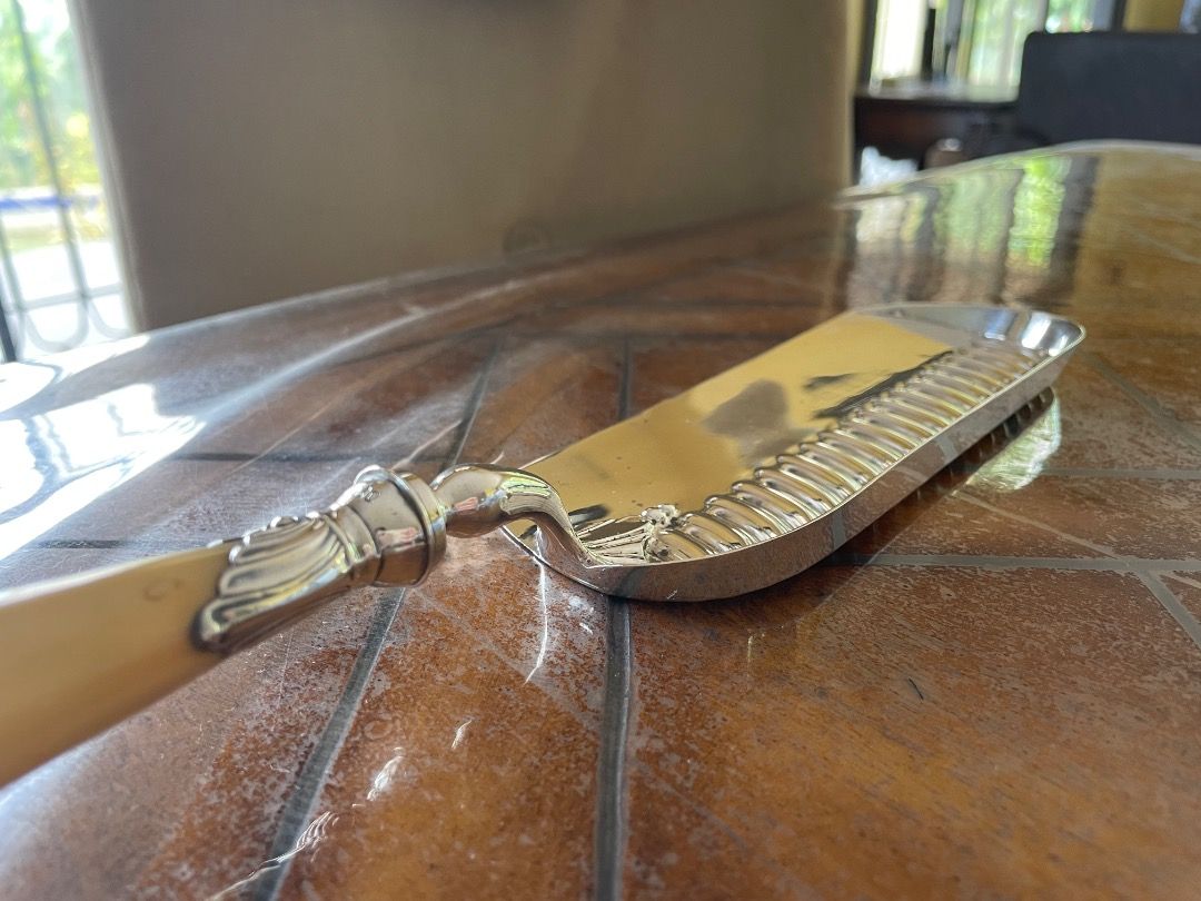 Edwardian Solid Silver and Ivory Crumb Scoop (Category: Vintage Collectibles) located in Caloocan City. Submitted by eu_antiques53 (Listing ID 1462390447, Image 3). Description: 1901-1910 - Hallmarked for London 1905/6 with makers mark for William Hutton & Sons. - With an ivory handle embellished with hallmarked silver scrolling and fluted mounts Length: 35cm Width : 7cm (at widest point) Weight: 266 grams.