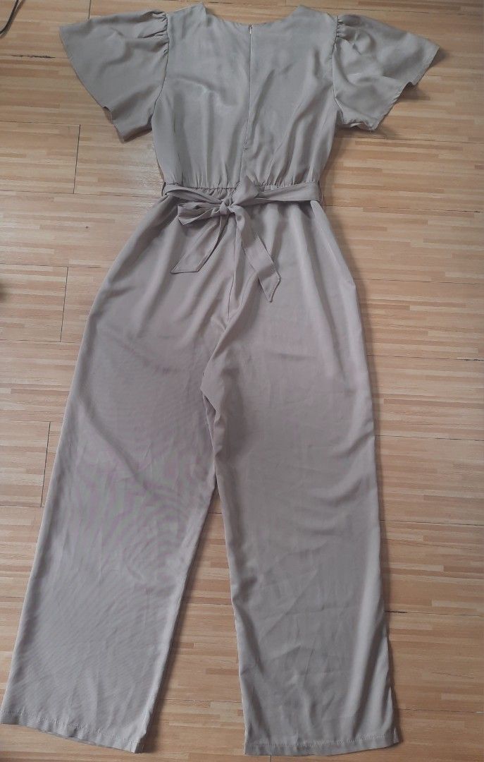 Elegant Khaki Jumpsuit (Category: Jumpsuits) located in Quezon City. Submitted by dannikkishoppe2 (Listing ID 1462387486, Image 3). Description: Elegant Khaki Jumpsuit ❗️₱400❗️ - Flattering flutter sleeves - Secure wrap front with adjustable tie waist - Comfortable wide leg pants - Measurements: Shoulder to ankle 55", Chest 16", Waist 14" - Sizing: Fits L to XL - Versatile for casual outings or dressing up.