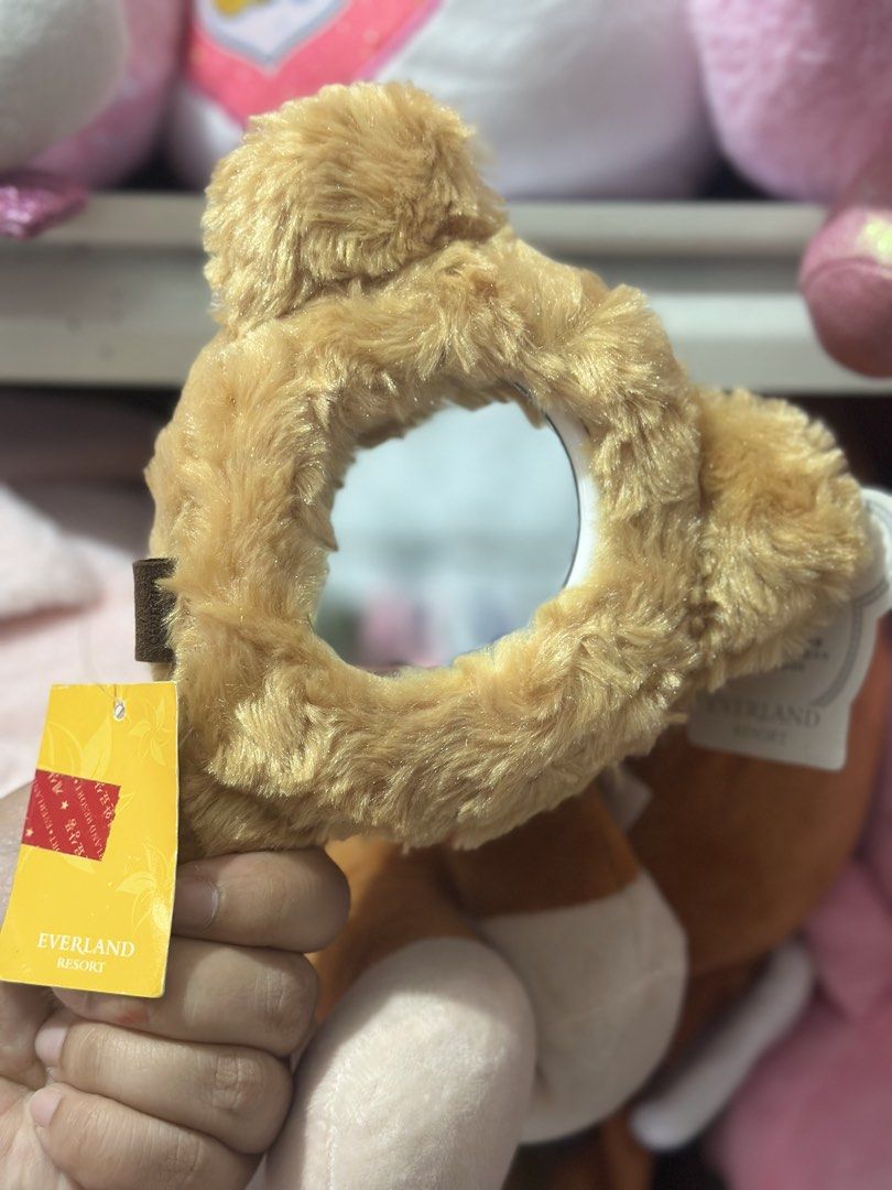 Everland Resort Heart Mirror Keychain (Category: Character Goods) located in Baguio. Submitted by cherylcaps95 (Listing ID 1462342065, Image 2). Description: - Adorable heart-shaped mirror keychain - Fuzzy brown material - Features a small mirror in the center - Includes a chain for easy attachment - Ideal accessory for your bag or keys - Authentic item from Everland Resort.