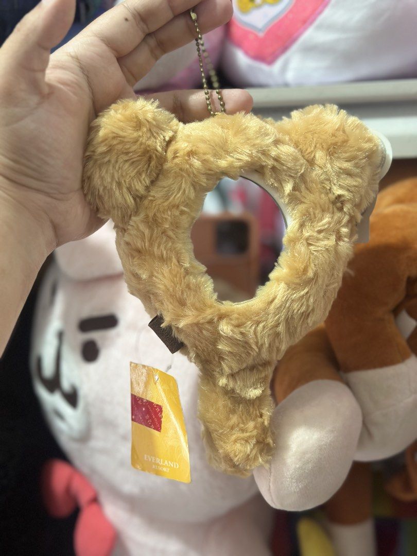 Everland Resort Heart Mirror Keychain (Category: Character Goods) located in Baguio. Submitted by cherylcaps95 (Listing ID 1462342065, Image 1). Description: - Adorable heart-shaped mirror keychain - Fuzzy brown material - Features a small mirror in the center - Includes a chain for easy attachment - Ideal accessory for your bag or keys - Authentic item from Everland Resort.