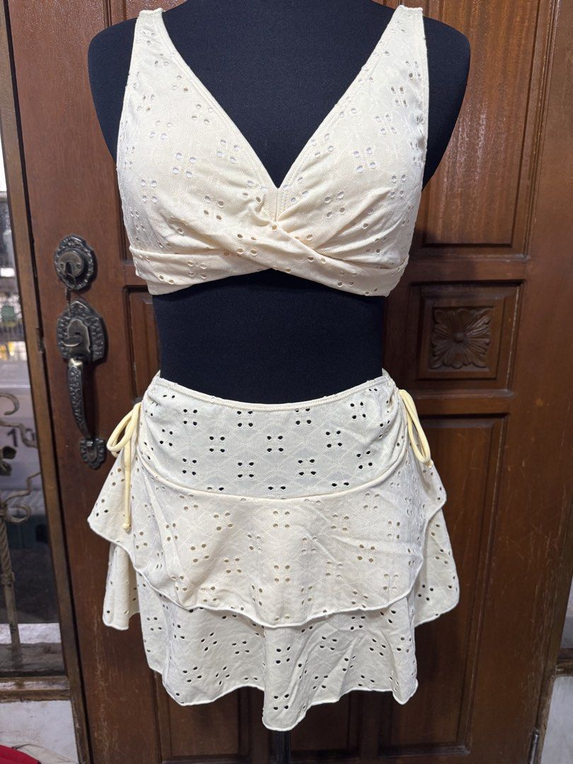Eyelet Bikini Set with Ruffled Skirt - Size M (Category: Bikinis & Swimsuits) located in Manila. Submitted by prelovedshopmnl (Listing ID 1462275671, Image 1). Description: - Light yellow eyelet bikini set - Twisted front top - Ruffled tiered skirt - High-waisted bottoms - Material: 95% polyester, 5% elastane - Ideal for beach days and pool parties - Comfortable and stylish design.