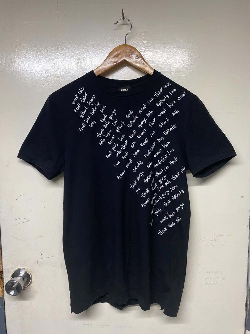 Fendi Black T-shirt with White Script Print (Category: Tshirts & Polo Shirts ) located in Pasig City. Submitted by jstnisidor81288 (Listing ID 1462420423, Image 1). Description: - Features a white script print on the front - Made in Italy - Model number: FY0626A1BH - Size: 75 - Ideal for Fendi collectors and fans.
