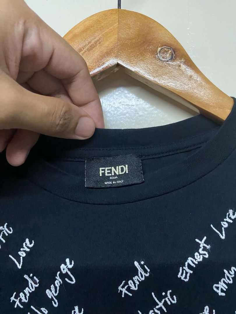 Fendi Black T-shirt with White Script Print (Category: Tshirts & Polo Shirts ) located in Pasig City. Submitted by jstnisidor81288 (Listing ID 1462420423, Image 3). Description: - Features a white script print on the front - Made in Italy - Model number: FY0626A1BH - Size: 75 - Ideal for Fendi collectors and fans.