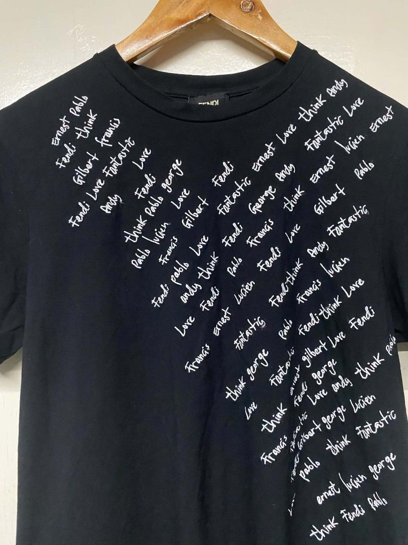 Fendi Black T-shirt with White Script Print (Category: Tshirts & Polo Shirts ) located in Pasig City. Submitted by jstnisidor81288 (Listing ID 1462420423, Image 2). Description: - Features a white script print on the front - Made in Italy - Model number: FY0626A1BH - Size: 75 - Ideal for Fendi collectors and fans.