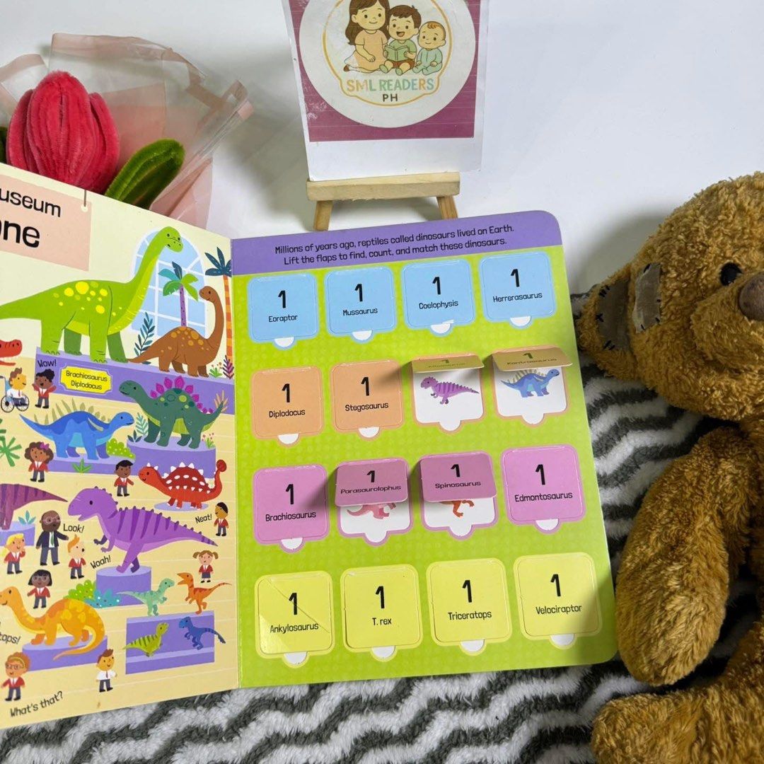 First 100 Dinosaurs to Count (Category: Children's Books) located in Taguig. Submitted by smlreadersph (Listing ID 1462360856, Image 3). Description: 💗 𝐋𝐢𝐟𝐭 𝐭𝐡𝐞 𝐅𝐥𝐚𝐩: 𝟏𝟎𝟎 𝐃𝐢𝐧𝐨𝐬𝐚𝐮𝐫𝐬 𝐭𝐨 𝐂𝐨𝐮𝐧𝐭 🦖🔢 Medium Lift-the-Flap Board Book • Imagine That Publishing 📖 Condition: Preloved with signs of use, including shelf wear along the edges, a sticker residue at the back cover, and a visible crease on one flap. All flaps are c