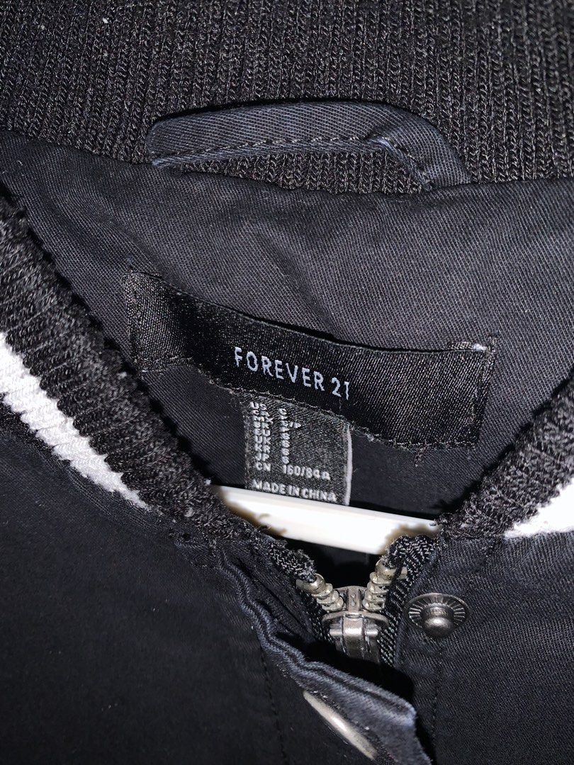 Forever 21 Black Varsity Bomber Jacket (Category: Coats, Jackets and Outerwear) located in Manila. Submitted by jo.arban (Listing ID 1462394588, Image 2). Description: - Classic black varsity bomber jacket from Forever 21 - White striped ribbed collar, cuffs, and hem - Snap button closure - Two side pockets - Ideal for casual wear and easy styling.