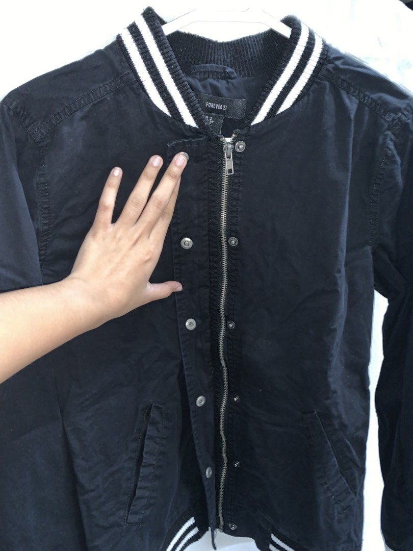 Forever 21 Black Varsity Bomber Jacket (Category: Coats, Jackets and Outerwear) located in Manila. Submitted by jo.arban (Listing ID 1462394588, Image 3). Description: - Classic black varsity bomber jacket from Forever 21 - White striped ribbed collar, cuffs, and hem - Snap button closure - Two side pockets - Ideal for casual wear and easy styling.