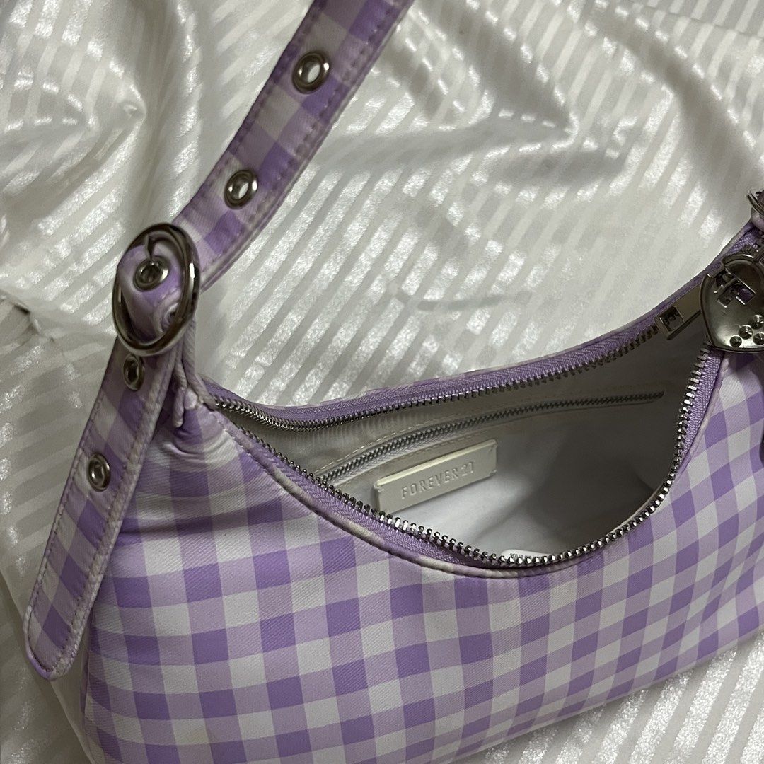 Forever 21 Gingham Y2K Shoulder Bag (Category: Shoulder Bags) located in Manila. Submitted by ave.archives (Listing ID 1462358371, Image 3). Description: Super cute and trendy Y2K-style shoulder bag from Forever 21! Featuring a lovely lilac and white checkered (gingham) pattern, grommet strap details, and comes with the adorable charms attached to the zipper pull. Perfect for adding a sweet, coquette, or vintage touch to your daily outfits. • Bra