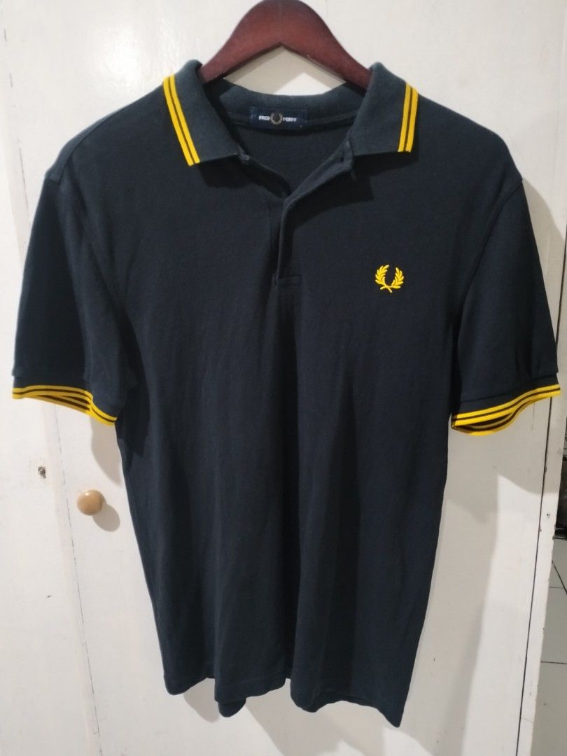 Fred Perry Polo Shirt Black Yellow Trim Size M (Category: Tshirts & Polo Shirts ) located in Quezon City. Submitted by j_tino_ishi260 (Listing ID 1462418521, Image 1). Description: - Classic Fred Perry polo shirt - Navy blue with yellow collar and sleeve trim - Iconic embroidered laurel wreath logo on chest - Size: Medium (M) - Made in China - Perfect for casual wear.