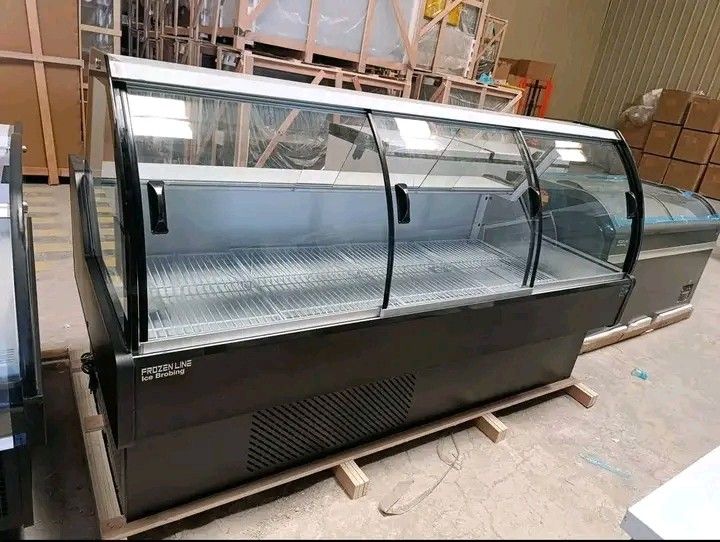 Frozenline Ice Broiling Display Refrigerator (Category: Refrigerators and Freezers) located in Liloan. Submitted by jen_adartel (Listing ID 1462281728, Image 1). Description: - Frozenline Ice Broiling display refrigerator - Curved glass front with sliding doors - Ideal for displaying chilled food items - Features internal shelves - Some units still wrapped in plastic - Located in a warehouse - Ready for pickup.