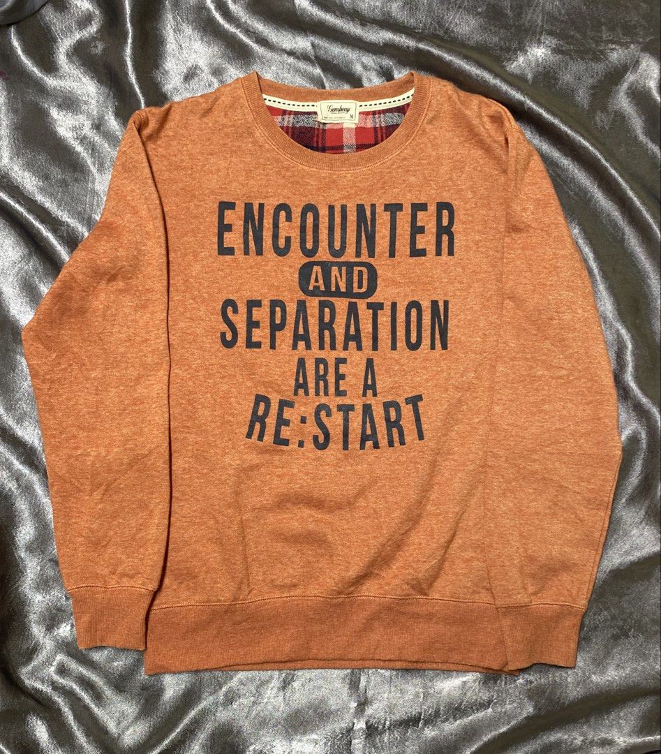 Gembony Orange Graphic Sweatshirt M (Category: Longsleeves) located in Agdangan. Submitted by kevinthriftshop (Listing ID 1462301373, Image 1). Description: - Brand: Gembony - Color: Orange - Size: M - Graphic print on front: 'ENCOUNTER AND SEPARATION ARE A RE:START' - Plaid lining around the collar - Material: Polyester and Cotton blend.