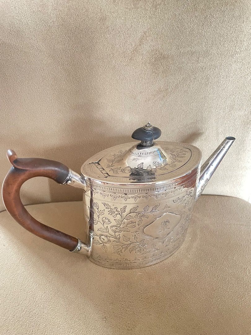 George III Solid Sterling Silver Teapot (Category: Luxury Accessories) located in Caloocan City. Submitted by eu_antiques53 (Listing ID 1462368057, Image 2). Description: - Tapered oval shape with engraved design and crested shield - fine original fruitwood handle - good clear hallmarks for London 1792. - Maker: William Sutton - Slight stress fissure around hinge and finial with small faults. - Excellent original condition with no damage or repai