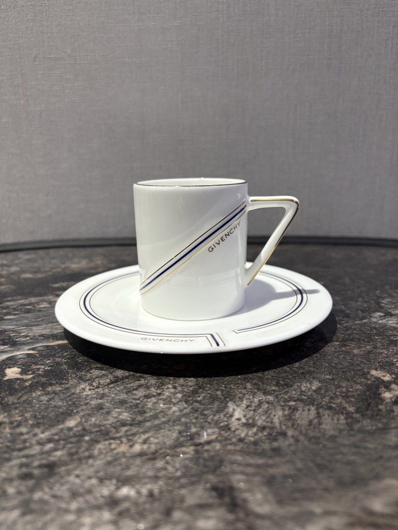 Givenchy Espresso Cup and Saucer Set (Category: Coffee & Tea Tableware) located in Manila. Submitted by foundhouseph (Listing ID 1462367050, Image 1). Description: - White porcelain espresso cup and saucer - Features elegant gold and navy blue stripe details - Authentic Givenchy logo on both cup and saucer - Ideal for enjoying your morning espresso - Doubles as a sophisticated display piece - Clean and timeless design - With minimal gold rub on t