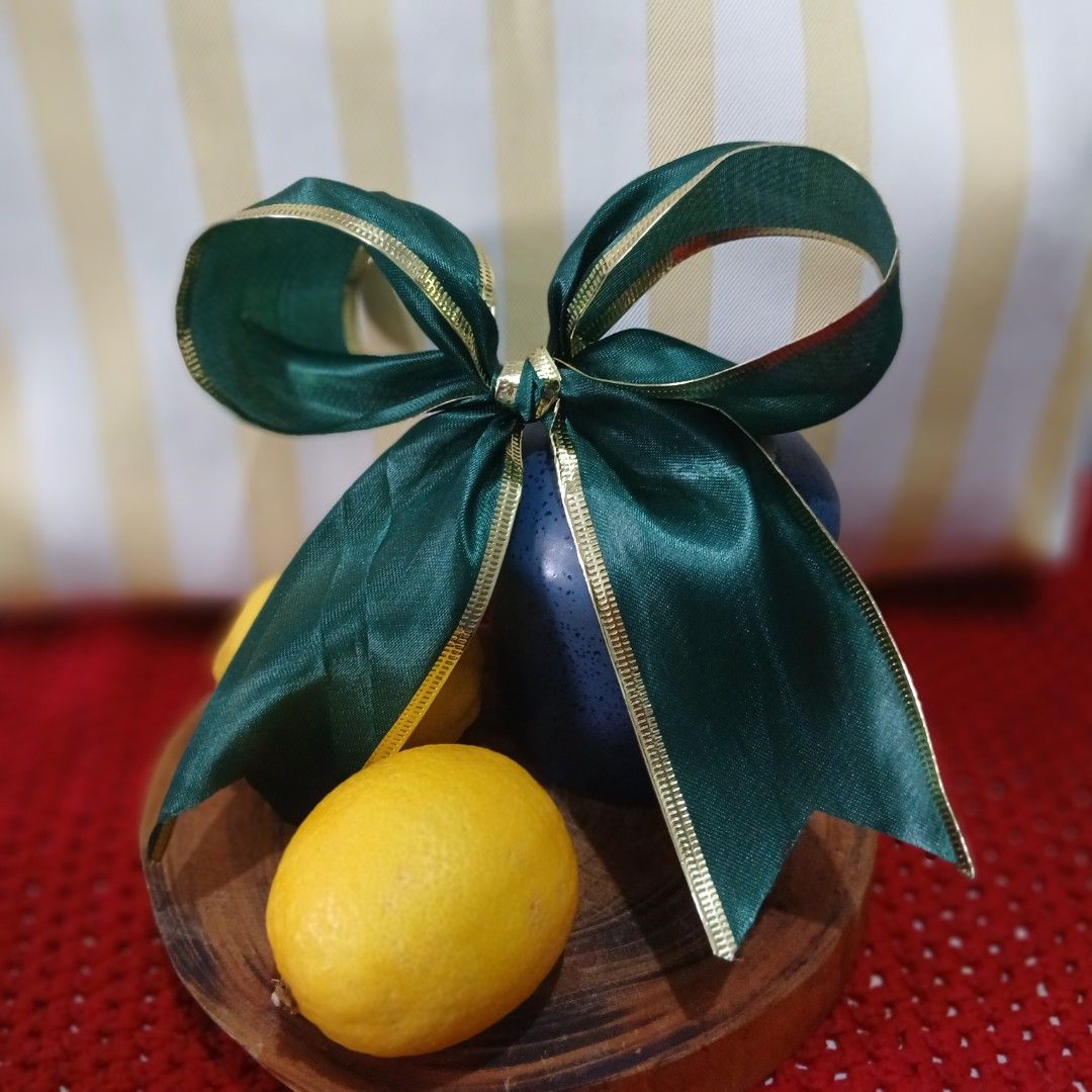 Green Ribbon (Category: Vases & Decorative Bowls) located in Valenzuela. Submitted by janninemose (Listing ID 1462331397, Image 1). Description: - Wooden bowl - Includes 2 decorative blue eggs - Includes 2 lemons - Tied with a dark green ribbon with gold trim - Ideal for display or as a unique centerpiece - Adds a pop of color to any room - Perfect for Easter or general decor.