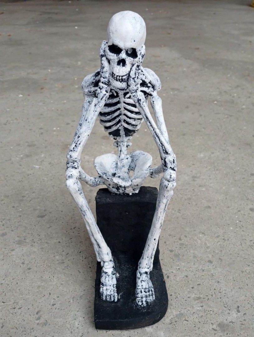 Grim Reaper: Hear No Evil, Skeleton statue Resin 15" (Category: Figurines & Statues) located in San Mateo. Submitted by waynetek14 (Listing ID 1462384982, Image 2). Description: - Unique skeleton statue in a contemplative pose. - Sits on a sturdy black base. - Ideal for Halloween decorations or as a quirky statement piece. - Crafted from resin. - Stands approximately 15 inches tall. - Exhibits a charming, slightly aged aesthetic .